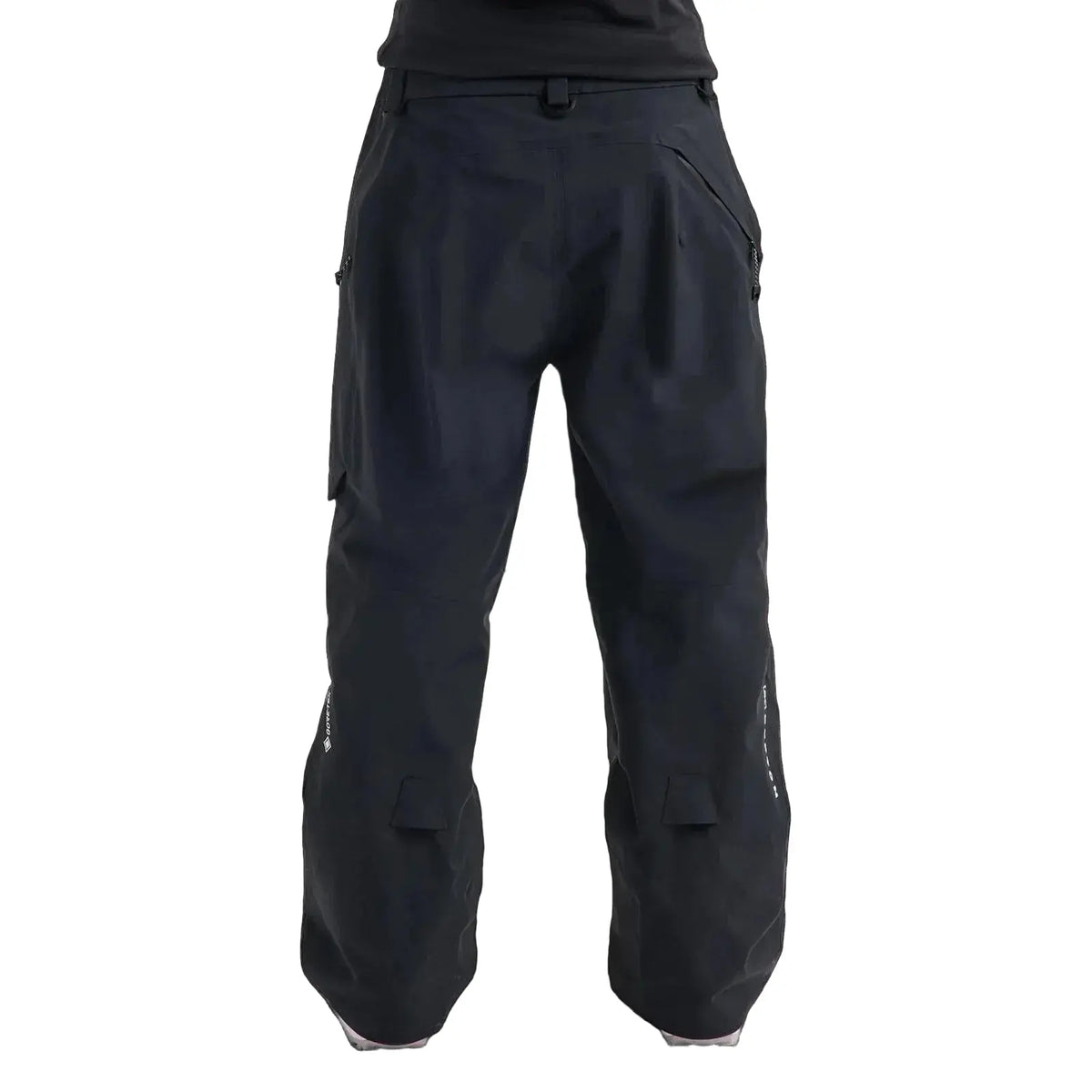 Black snowboard pants shown from the back, featuring a belt loop, side cargo pockets, and reinforced knee panels, photographed against a light gray studio background.